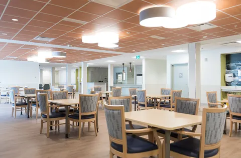 Dining room with wooden tables, chairs and ceiling lights.