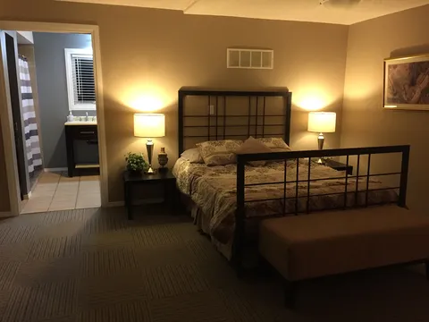 Bedroom with a double bed, bedside lamps and a doorway to the bathroom.