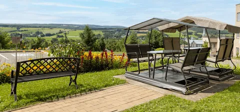 Garden seating with a bench, a covered table and views over green fields
