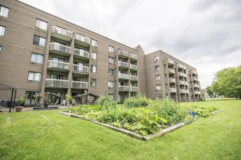 Brick residence with balconies overlooking a communal garden.