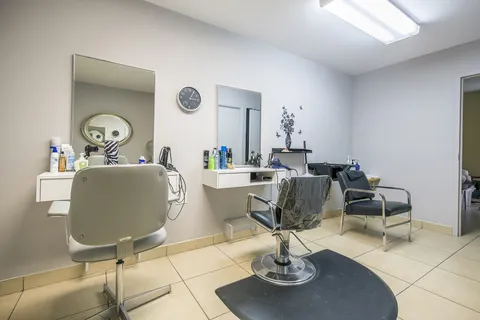 Hair salon with styling chairs and mirrors.