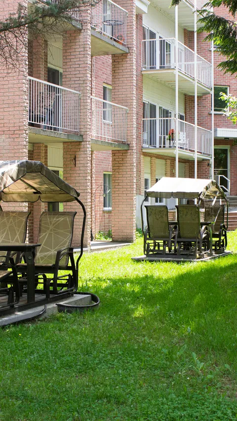 Lawn and covered outdoor swings beside the residence.