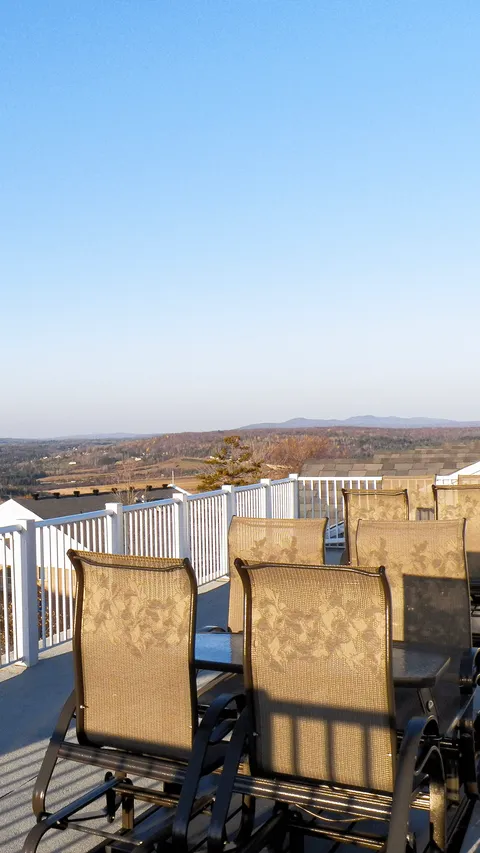 Rooftop patio with outdoor chairs and a white railing.