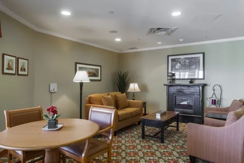 Room with a dining table, sofas, a fireplace and framed pictures