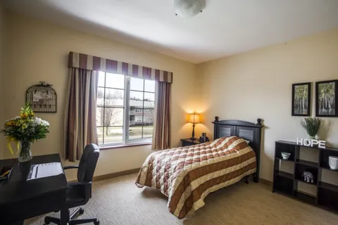 Bedroom with a bed, desk and window