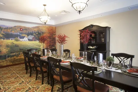 Long dining table beneath a mural of a farm landscape