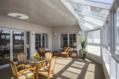 Sunroom with wicker chairs, tables and large windows