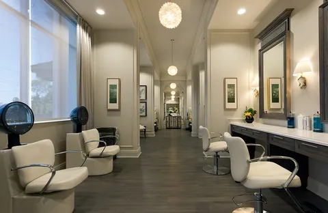 Salon with styling chairs, mirrors and windows.