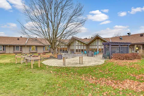 Lawn and raised garden beds beside a residence courtyard and patio