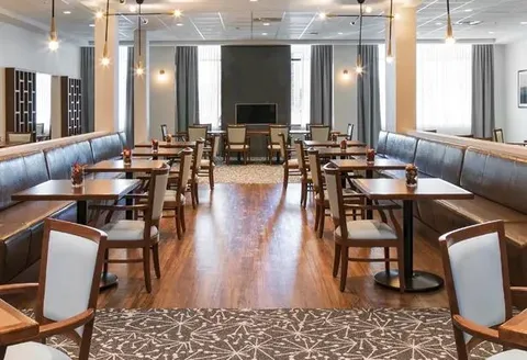 Dining room with tables, chairs and upholstered booth seating.