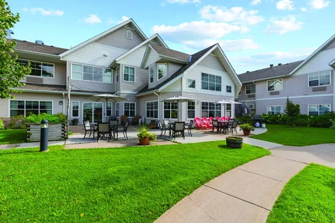 Residence building overlooking a lawn, paths and patio seating