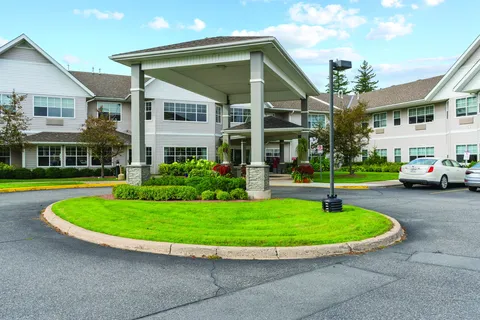Covered entrance beside a circular driveway and landscaped island
