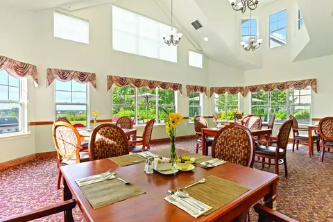 Dining room with set tables, patterned chairs and tall windows