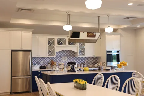 Kitchen with blue cabinets, a white island, patterned tiles and stainless steel appliances