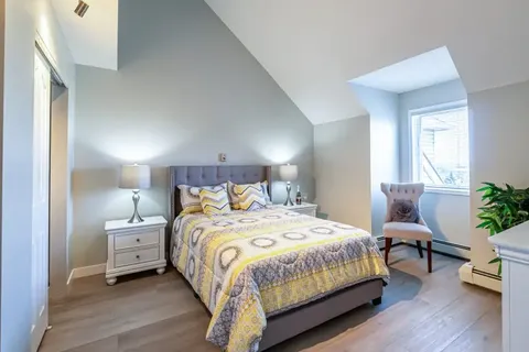 Bedroom with a bed, yellow patterned bedding and bedside tables