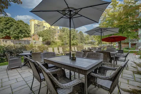 Garden patio with woven chairs, tables and umbrellas