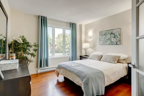 Bedroom with blue curtains, a bedside lamp and a grey bedspread