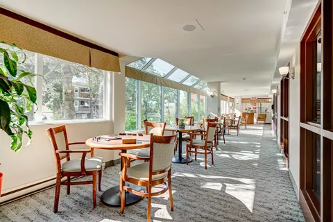 Sunroom with round tables, wooden chairs and large windows