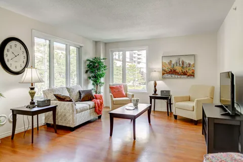 Sitting room with a patterned sofa, armchairs, coffee table and television