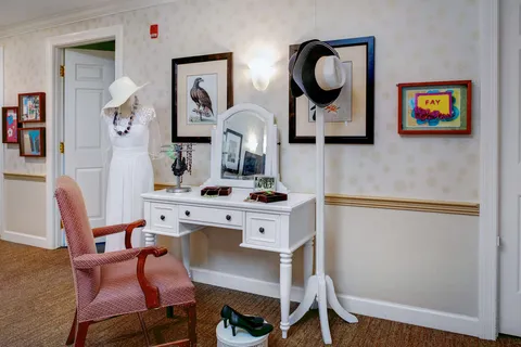 Sitting corner with a dressing table, mirror and pink chair.