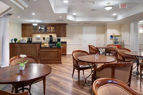 Bistro with round tables, wooden chairs and a drinks counter.