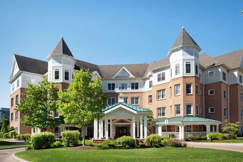 Residence exterior with brick walls, bay windows and a covered entrance.