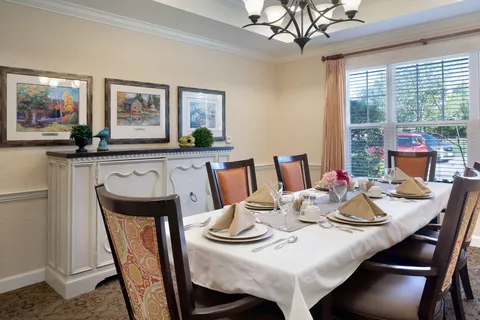 Private dining room with a long table, chairs and a window.