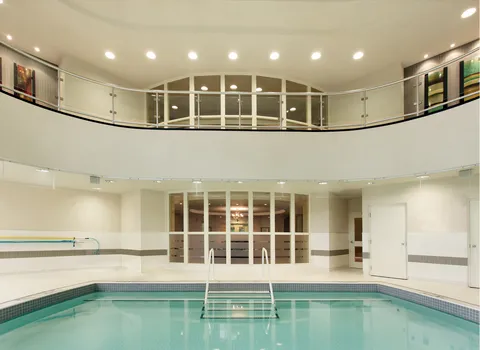 Indoor pool beneath an upper-level balcony.