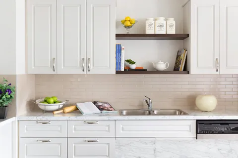 Craft kitchen counter with sink, cupboards and a recipe book.