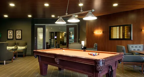 Pool table in a wood-panelled games room.