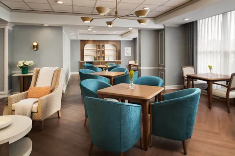 Sitting area with teal chairs and wooden tables