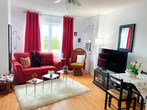 Suite living room with a red sofa and a television.