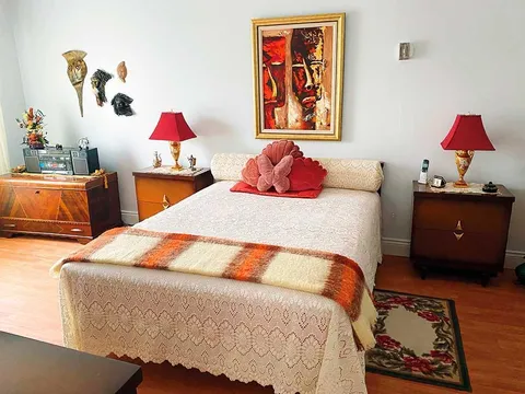 Suite bedroom with a double bed and wooden bedside tables.
