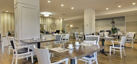 Dining room with set tables beneath recessed ceiling lights