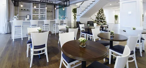 Cafe seating beneath a staircase beside a service counter