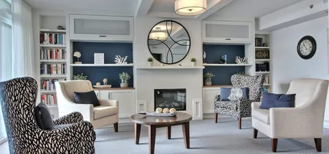 Library lounge with bookshelves, armchairs and a fireplace