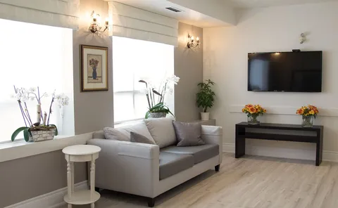 Lounge with sofas, armchairs and a large television.