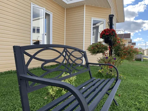 Garden bench and hanging flowers beside the residence entrance.