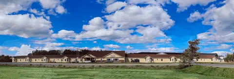 Wide view of the single-storey residence across a lawn.