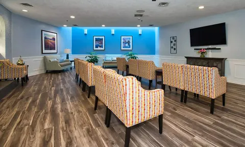 Screening room with sofas, armchairs and a large television.