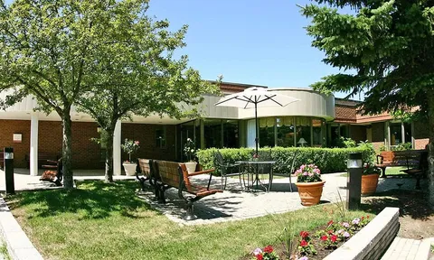 Courtyard seating among trees and flower planters.