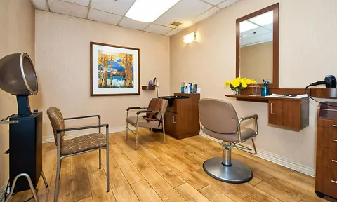 Salon with styling chairs, mirrors and hair dryers.