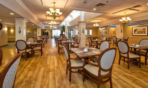 Dining room with set tables and upholstered chairs.