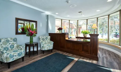 Reception area with a wooden desk and curved windows.