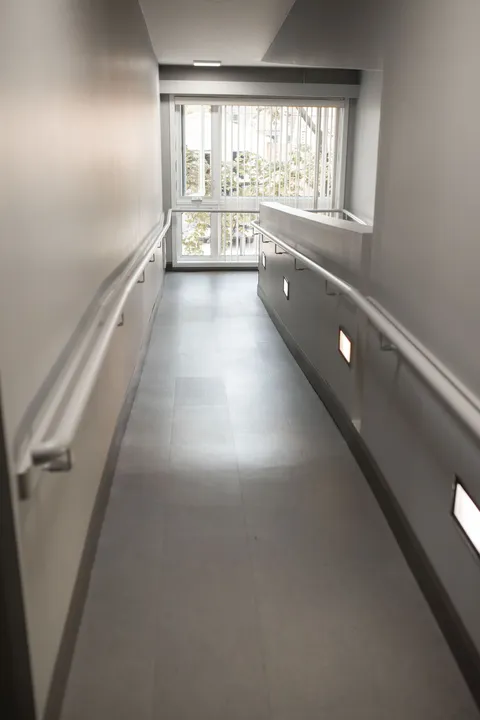 Corridor with handrails leading to a window