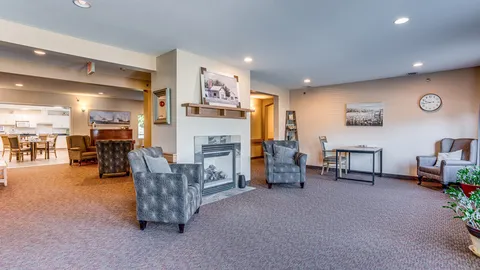 Lounge with armchairs and a central fireplace.