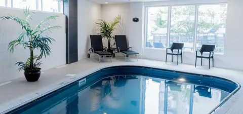 Indoor swimming pool with lounge chairs and potted plants