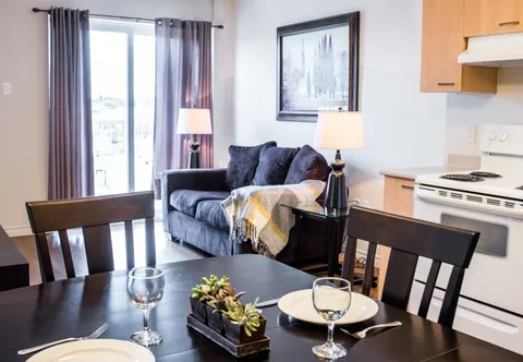 Dining table beside a kitchenette and a sofa