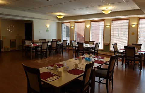 Dining room with tables, upholstered chairs and large windows