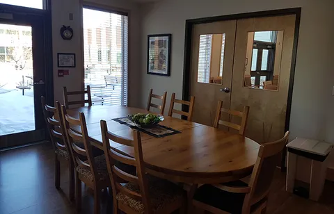 Small dining room with a table, chairs and framed pictures